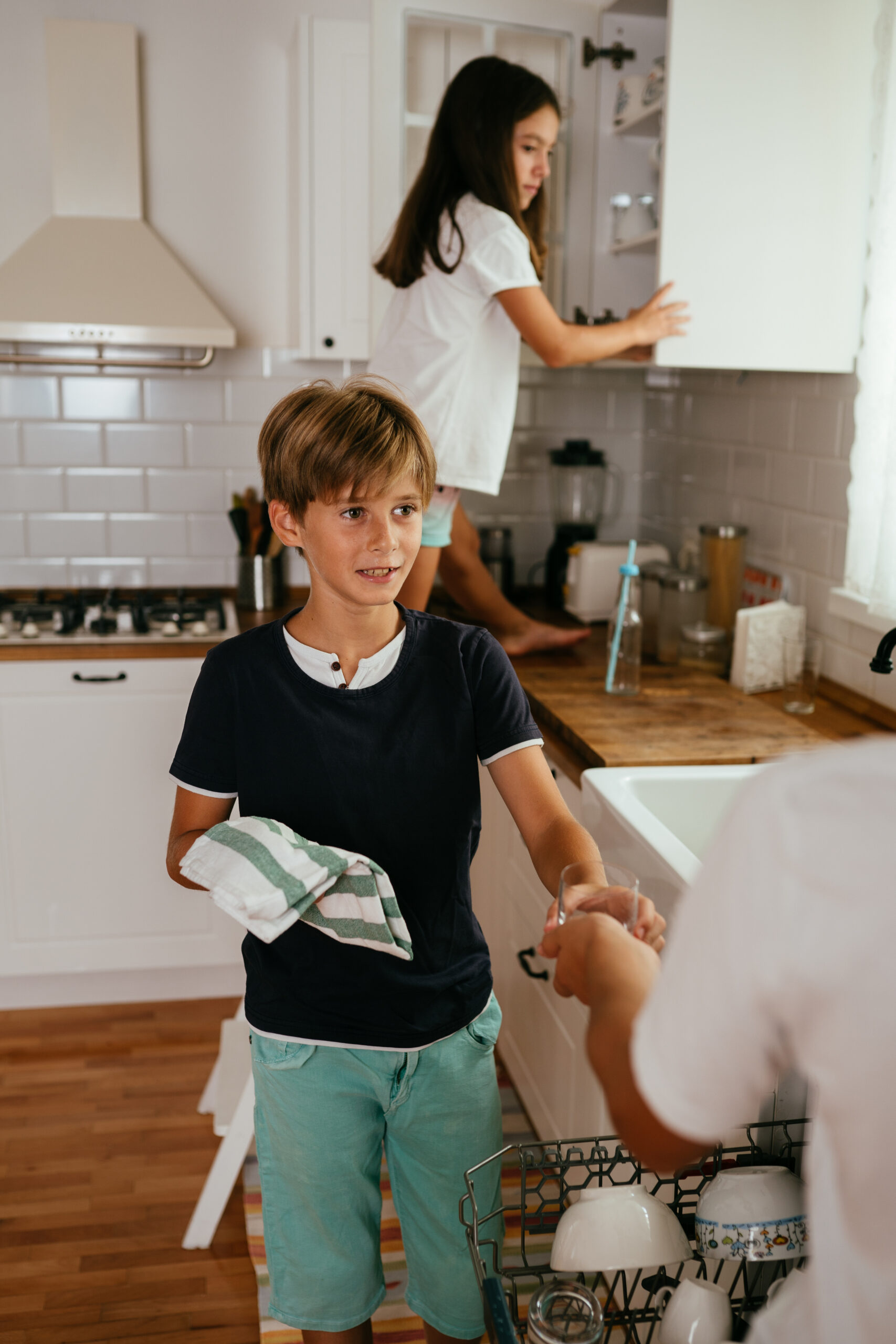 Children Taking Off Clean Dishes From The Diswasher